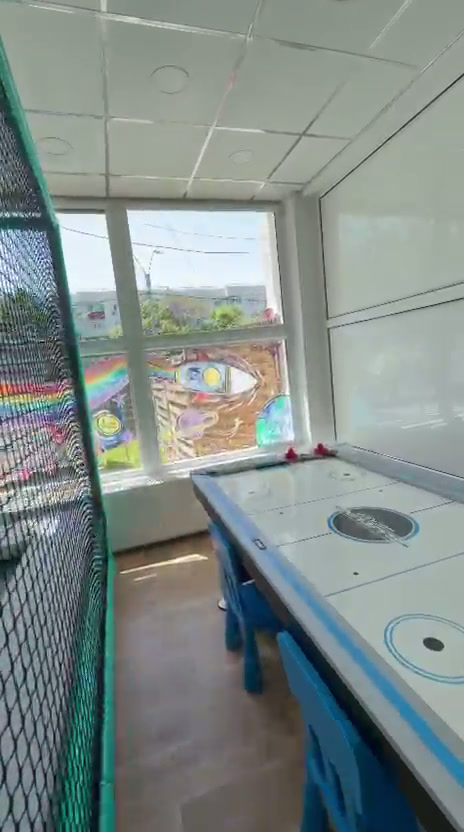 Zonă de jocuri cu masă de air hockey lângă structura de joacă